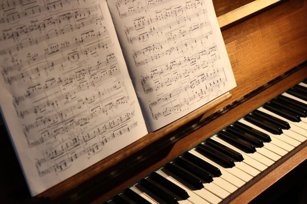 Open sheet music resting on an upright piano music desk