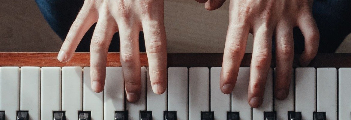 Hands practicing on an open piano keyboard
