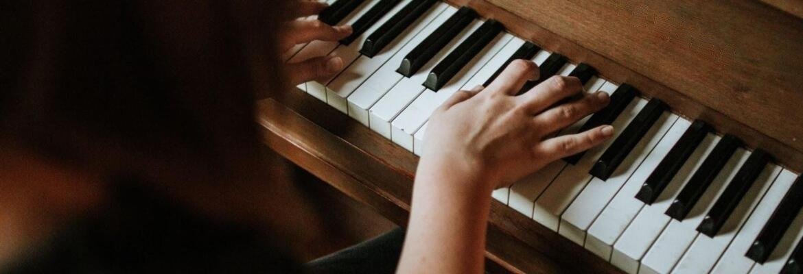 Hands playing an upright piano during a practice session